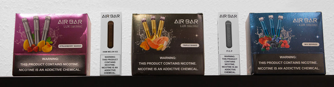 Wholesale Air Bar packaging in a row standing on a black counter top against white wall