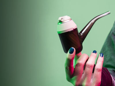 Woman holding Puffco Proxy Desert in front of green studio background