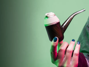Woman holding Puffco Proxy Desert in front of green studio background