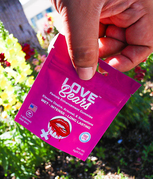 man holding Love Bears gummies outside
