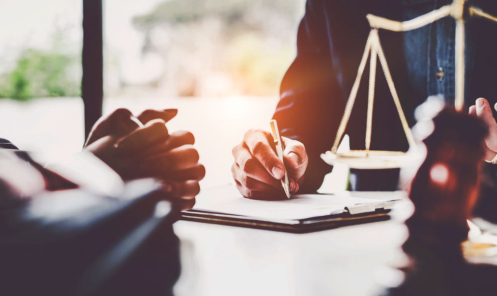 Lawyers discussing a law over a desk with scales nearby