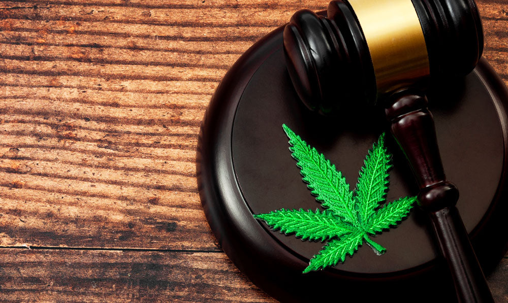 Gavel and Cannabis symbol resting together on wooden surface