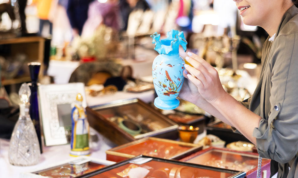 Woman looking at glass wares in a flea market