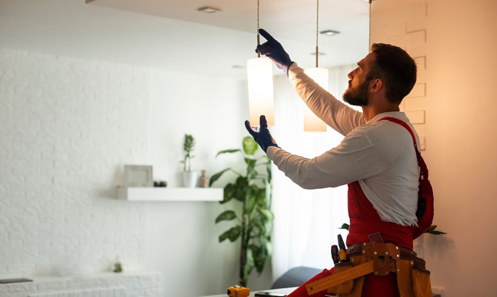 Worker adjusting interior lighting of a shop