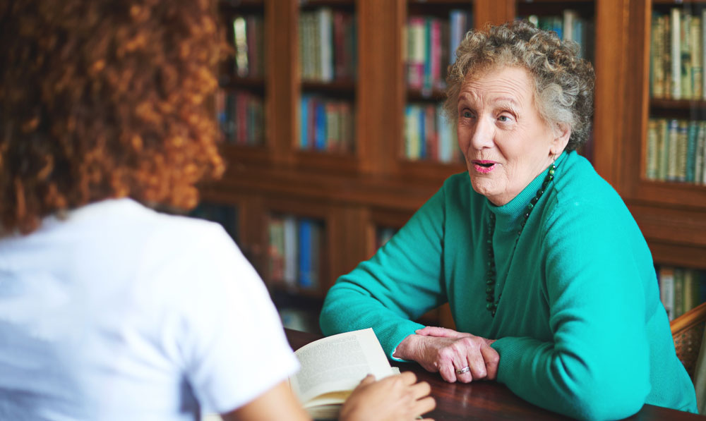 Two people speaking to each other in a library