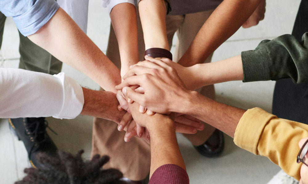 Retail team huddling up with hands in the middle