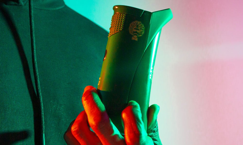 Man holding GPen Roam under green studio lighting
