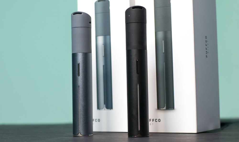 Puffco Pivot standing on black surface in front of green background