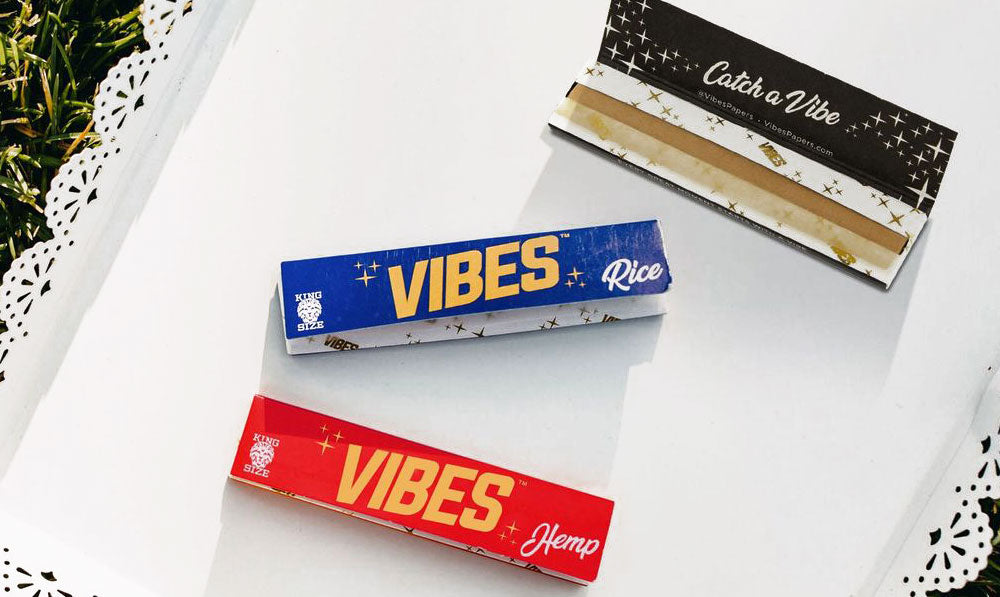 Vibes Papers resting on white doily tray on top of grassy surface