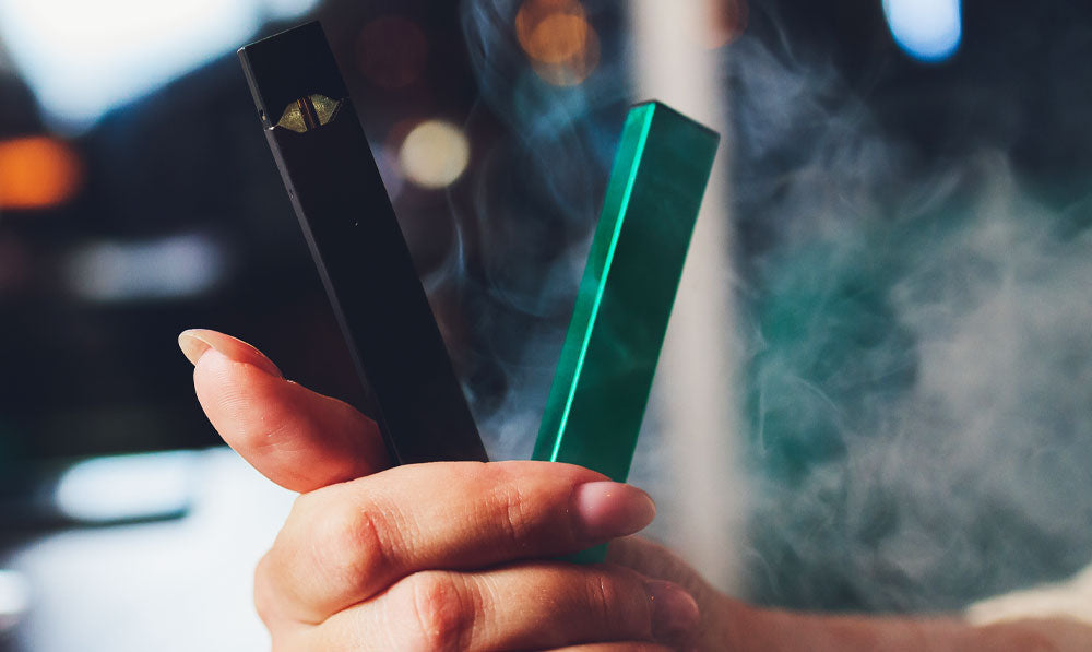 Woman holding two CBD vapes in hand