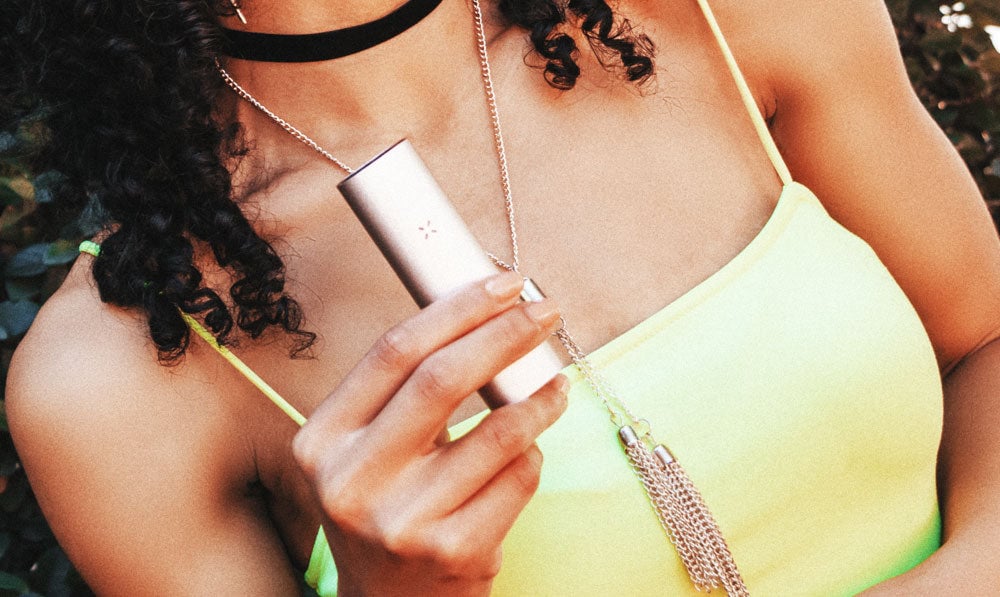Woman in green top holding PAX Mini under the sunlight
