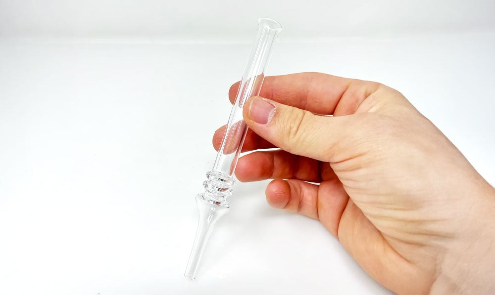 Person holding glass nectar collector above white surface