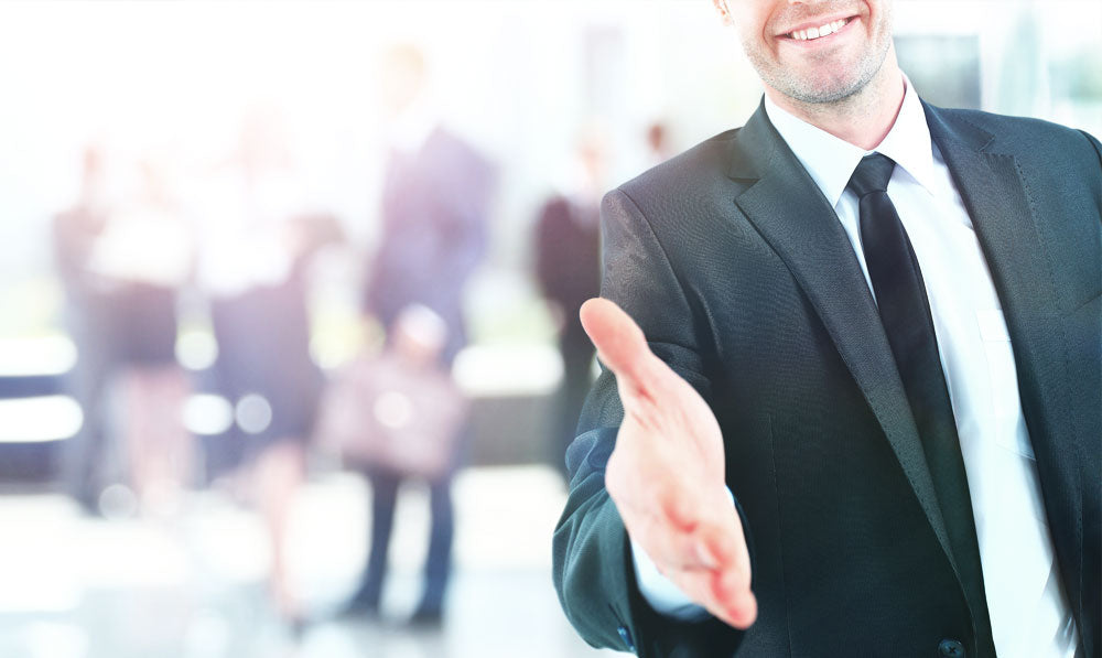 Friendly businessman with a smile extending a handshake