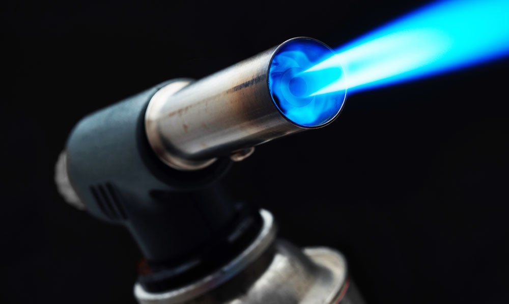 Closeup of a torch in use, with flame blowing