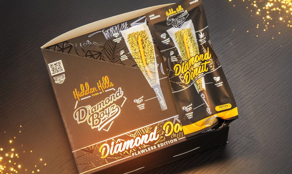 Hidden Hills Diamond Boyz Pre Rolls on dark surface with gold dust nearby