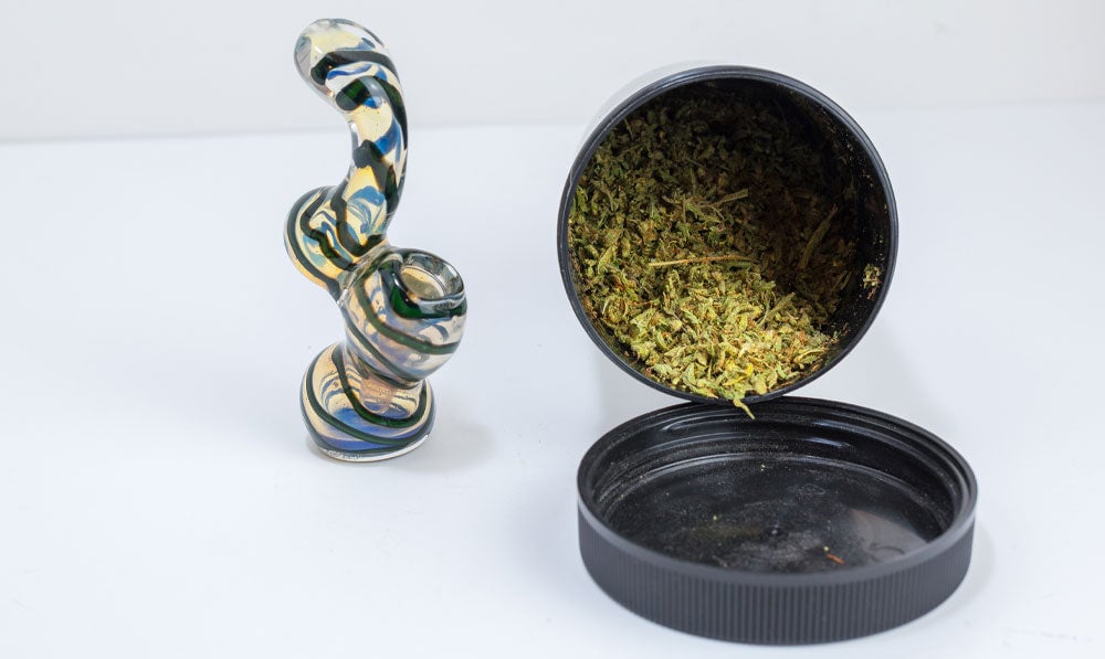 Small bubbler on white surface with dry herbs nearby