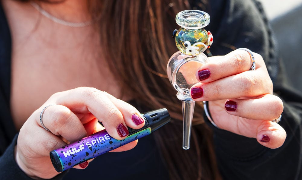 Woman holding Wulf Mods x Empire Glassworks Honey Straw Kit under sunlight