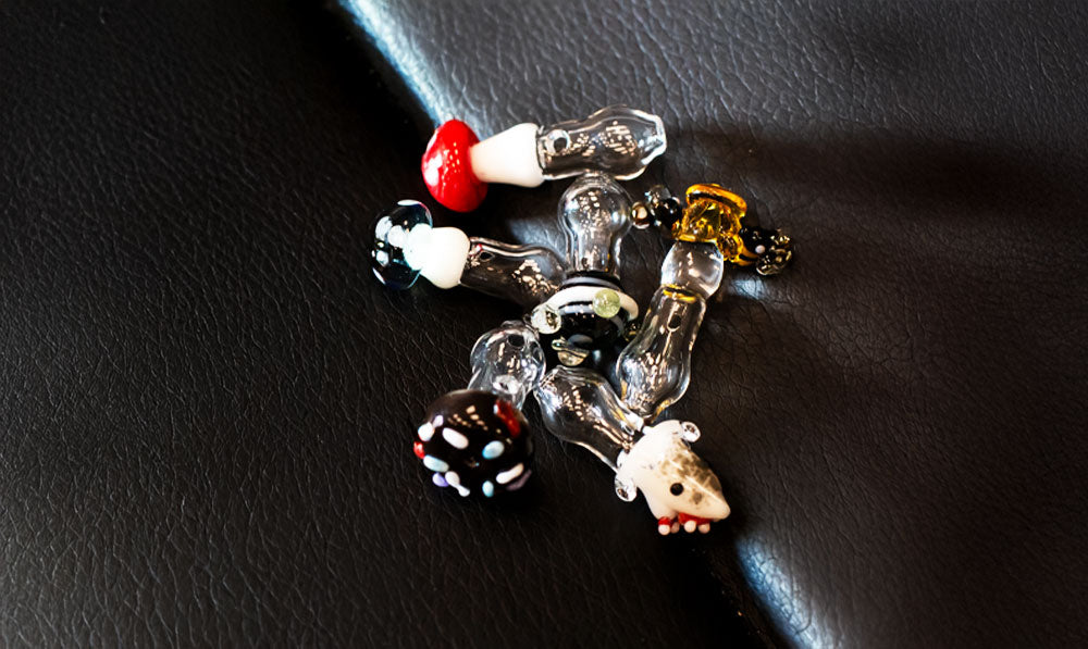 Empire Glassworks Puffco Proxy Ball Caps resting on leather surface