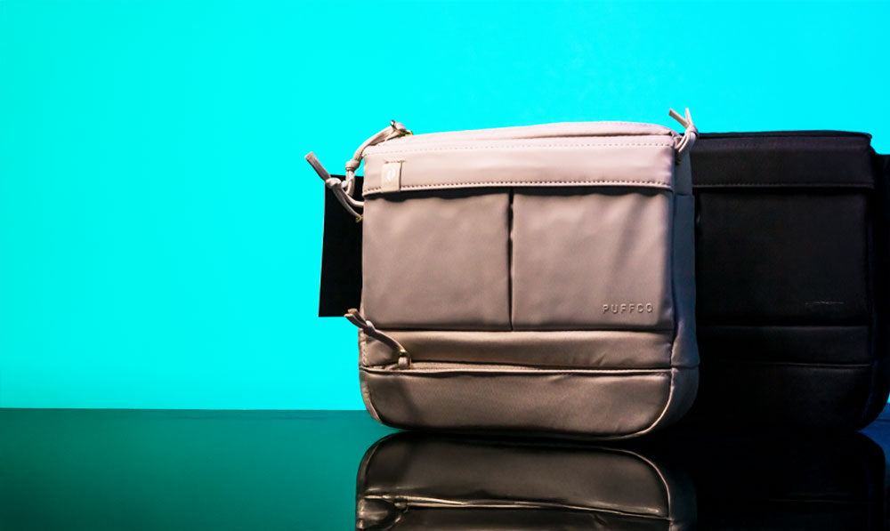Puffco Proxy Travel Bag resting on reflective surface in front of teal studio background