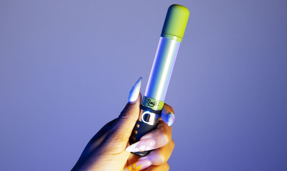 Hand holding Smyle Saber glowing in a dark room