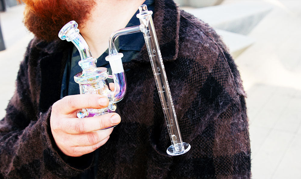 man holding dab rig with wulf challenge banger at park
