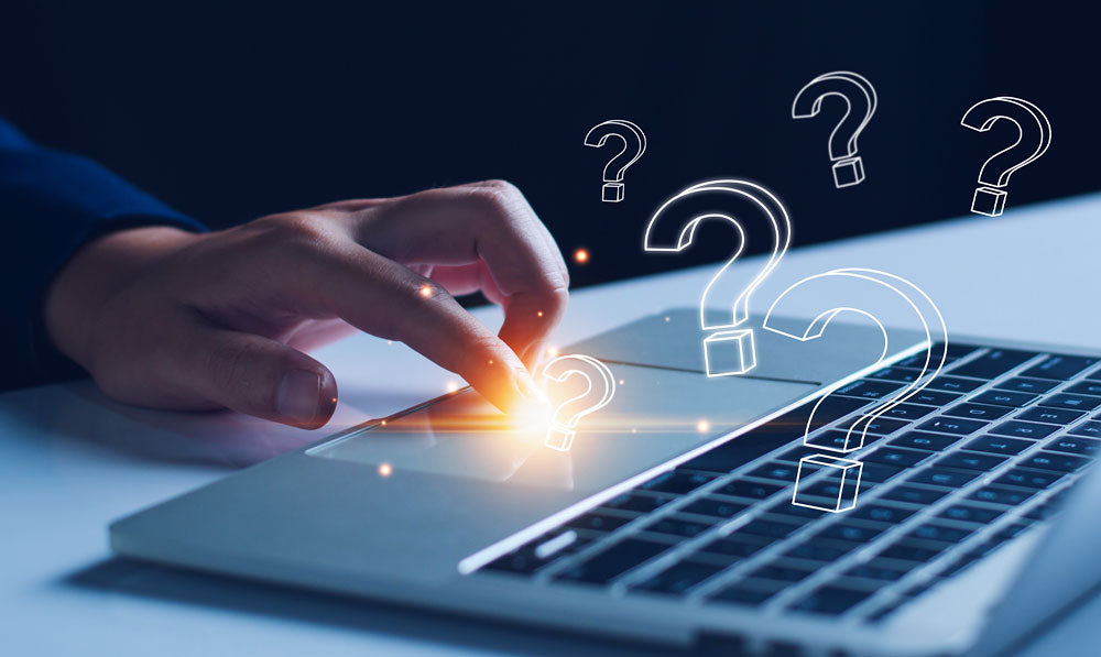 Person Typing Questions Into Laptop