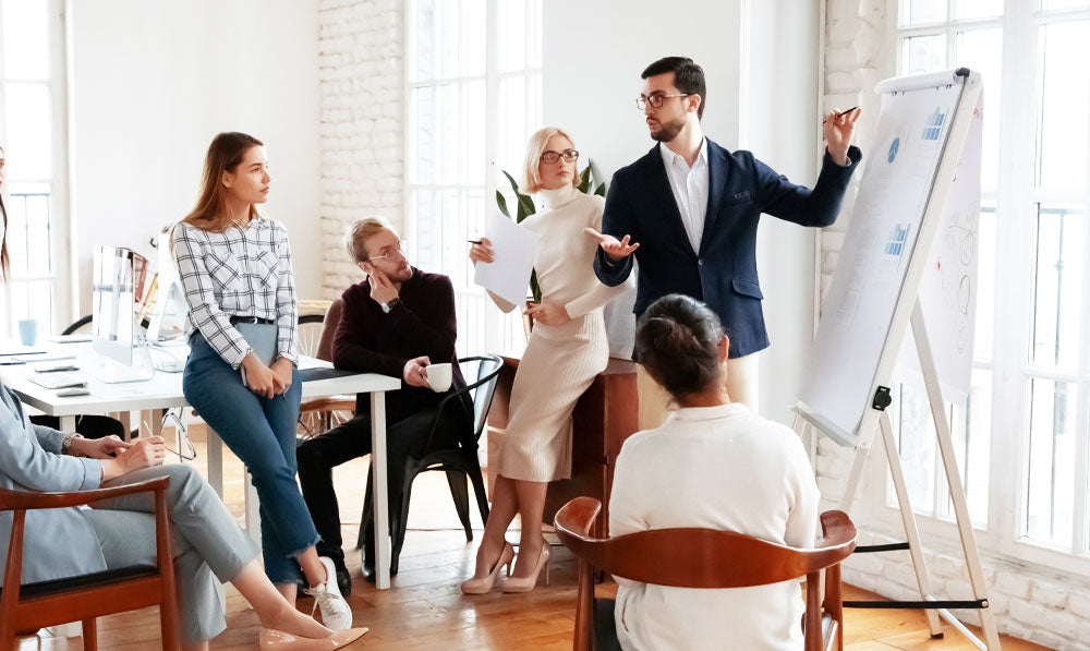 Male boss explaining business concepts to employees in a conference room
