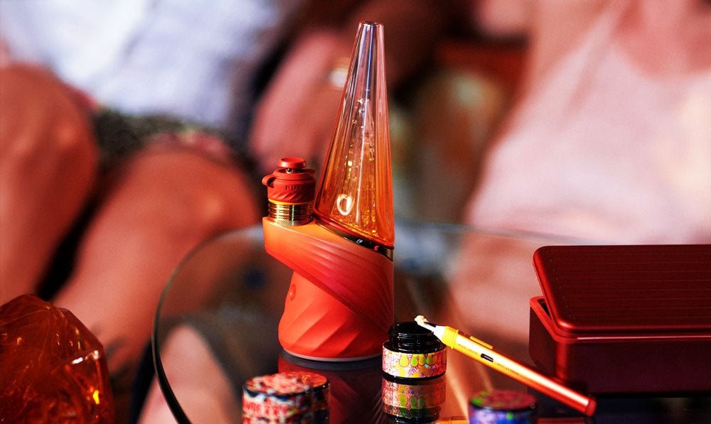 Puffco Daybreak Peak Pro on party table with people around