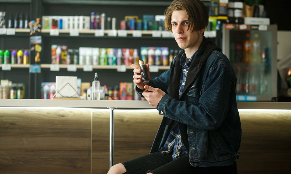 man at smoke shop bar with vaporizer looking towards camera