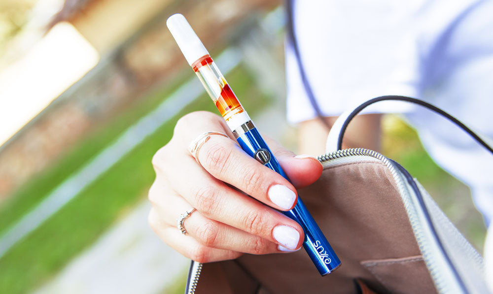 Woman pulling Exxus Slim VV 2.0 out of purse