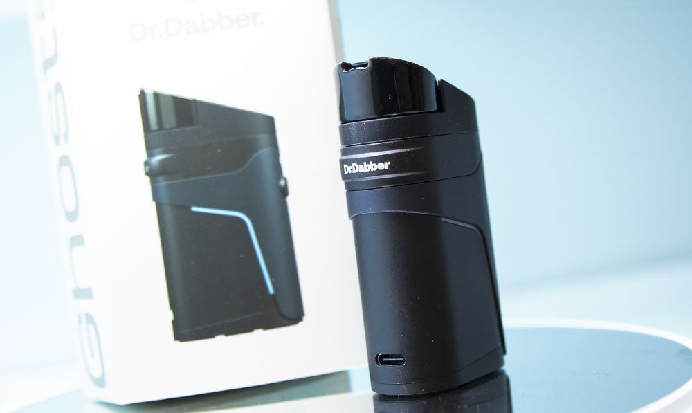 Dr. Dabber Ghost 2 standing on reflective display surface with packaging nearby