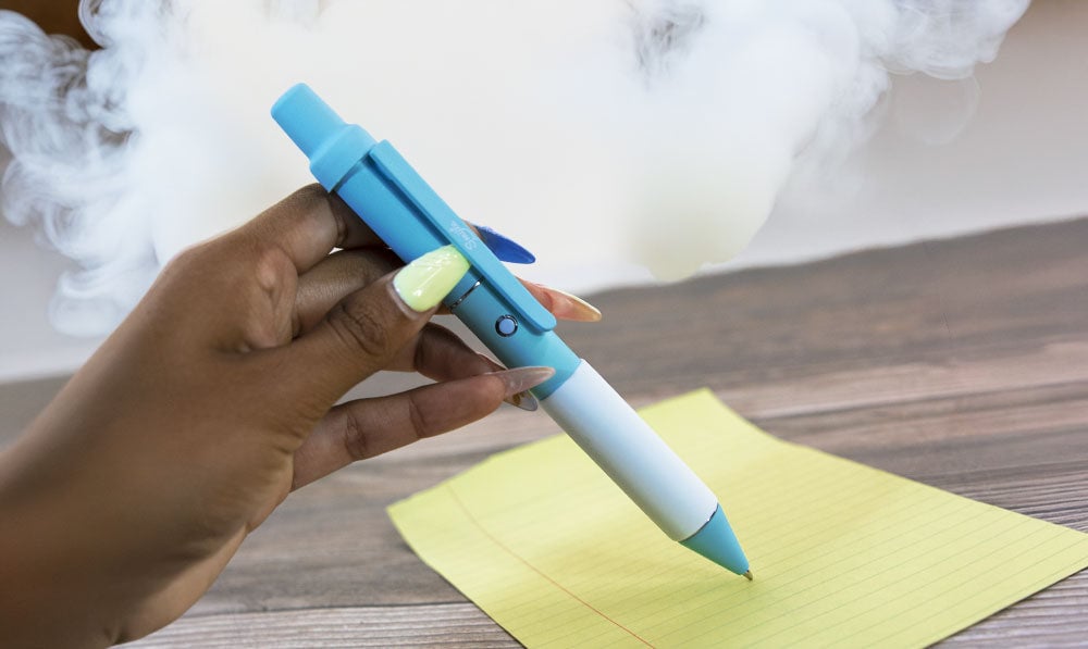 Woman using Smyle Penjamin on notebook paper with smoke clouds nearby