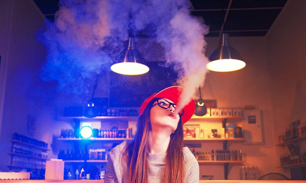 Woman vaping in smoke shop