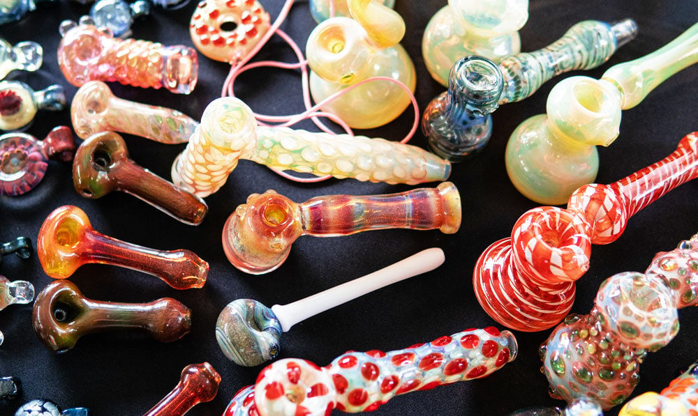 Collection of glass handpipes on dark surface
