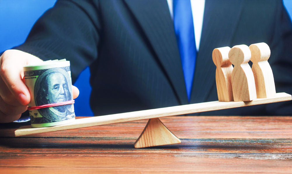 Businessman with wooden scale holding money and people