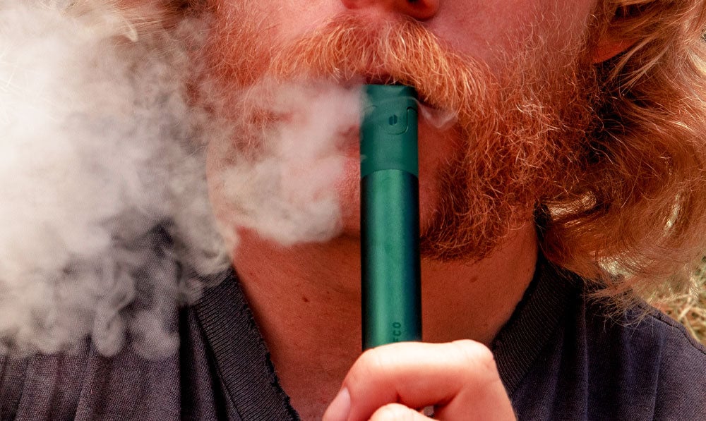 Closeup of bearded man using Puffco Pivot Pine