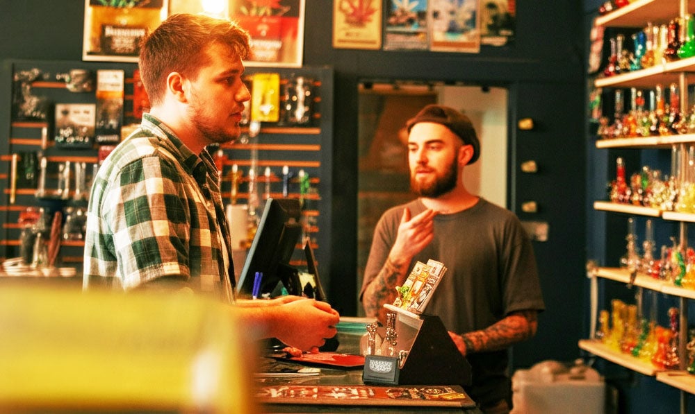 Employee Speaking To Customer In Neat And Colorful Smoke Shop