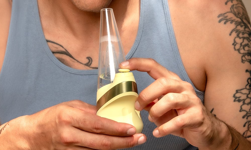 man holding Puffco Peak Zest Edition outdoors