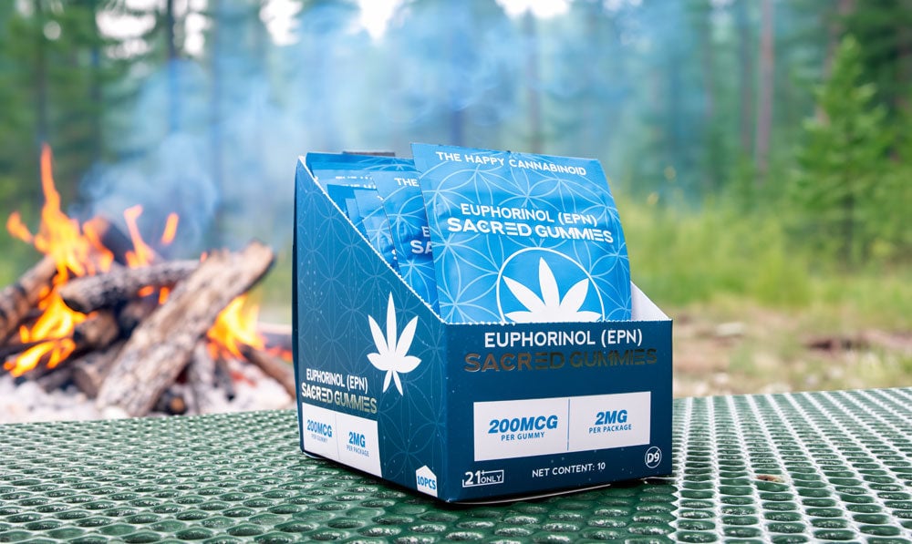 Sacred EPN gummies display box with campfire background