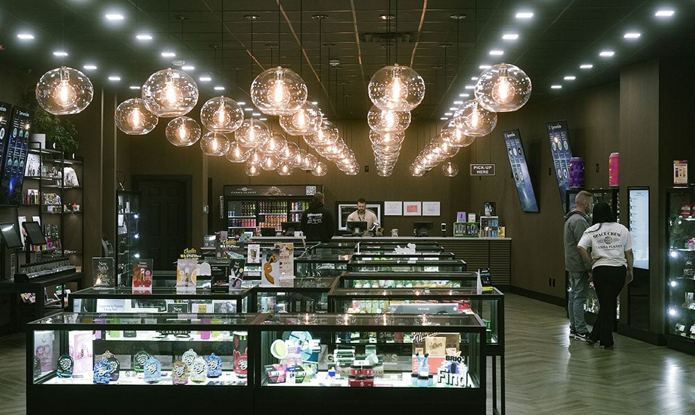 Interior of a smoke shop with lit display cases and pendant lighting