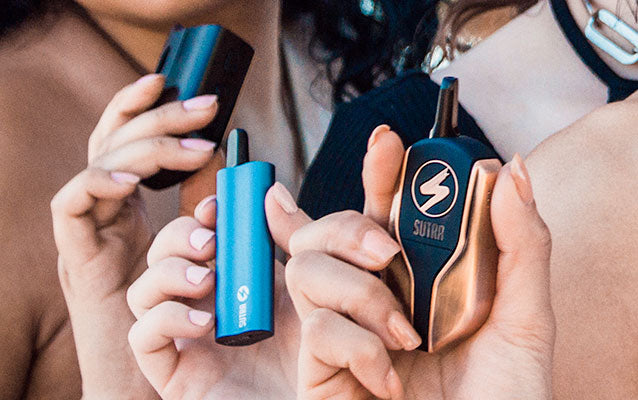 woman holding Sutra Vape products at park