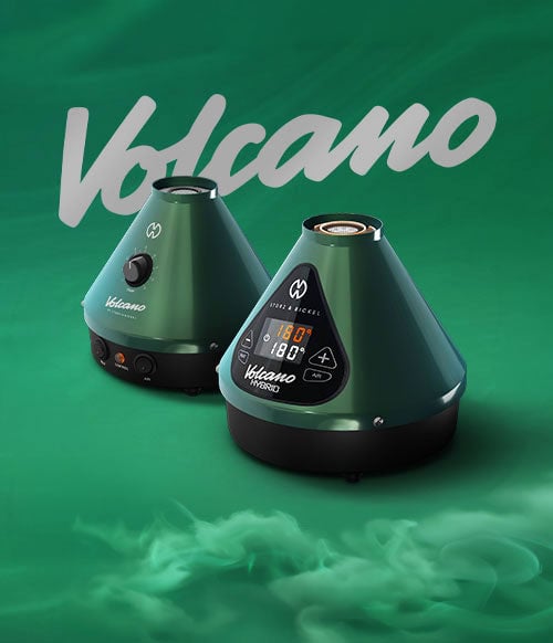 Storz & Bickel Veazy Evergreen Volcanoes on green surface with smoke clouds rolling