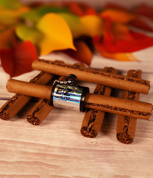EZ Splitz product resting on wooden desk with blunt wraps and leaves in the background