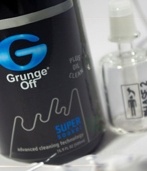 Grunge Off glass cleaner with glass bowl on white table