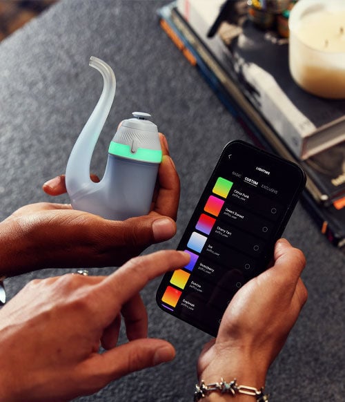 Hands holding Puffco New Proxy with phone