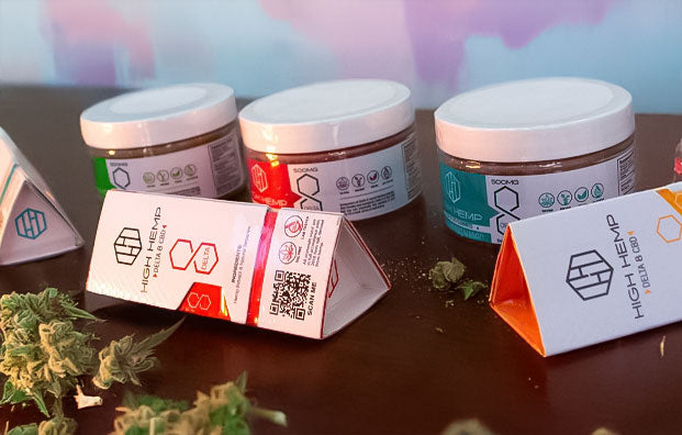 High Hemp products on table with hemp plants nearby