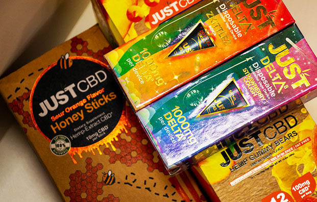 Just CBD Cartridges, gummies and honey sticks closeup