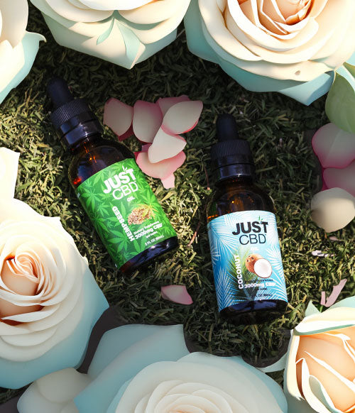 Just CBD Products in grass near flowers