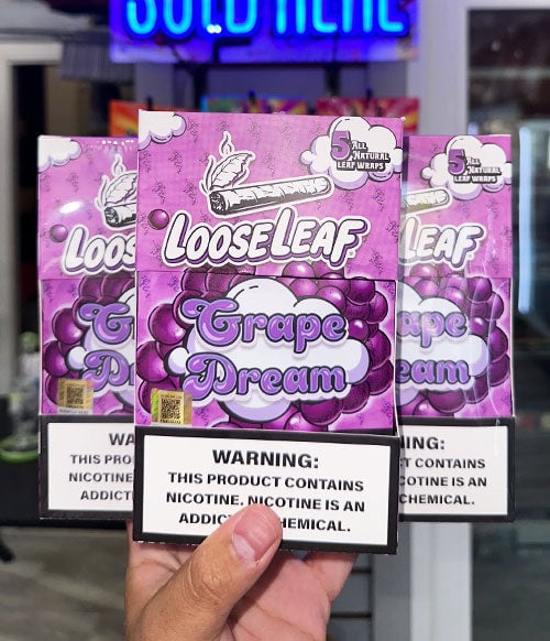 Person holding Loose Leaf wraps in front of store