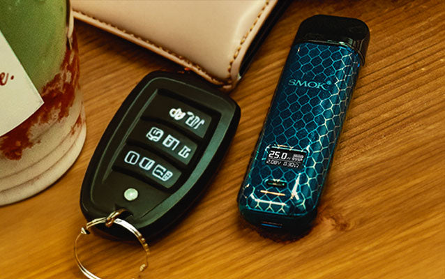 SMOK Novo 4 laying on coffee table with keys and wallet